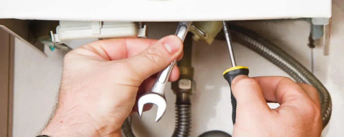 Boiler repair technician tightening pipe fittings and connections in Royal Oak, MI