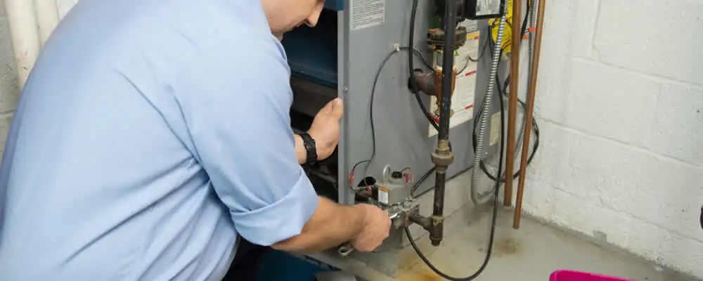 Furnace repair technician inspecting and servicing a home heating system in Royal Oak, MI