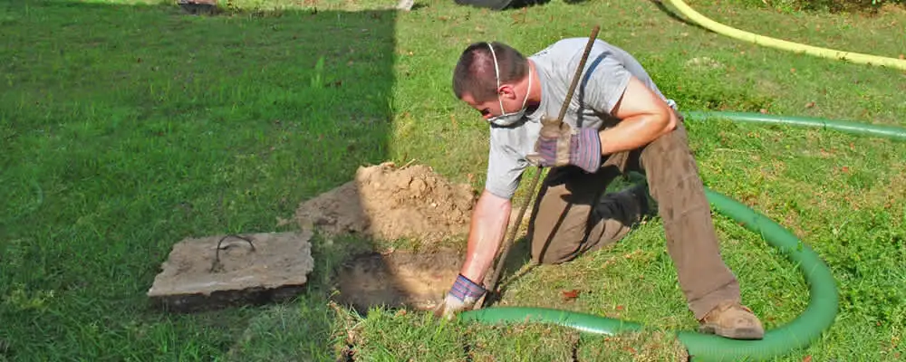 Septic pumping technician servicing a residential septic tank in Royal Oak, MI