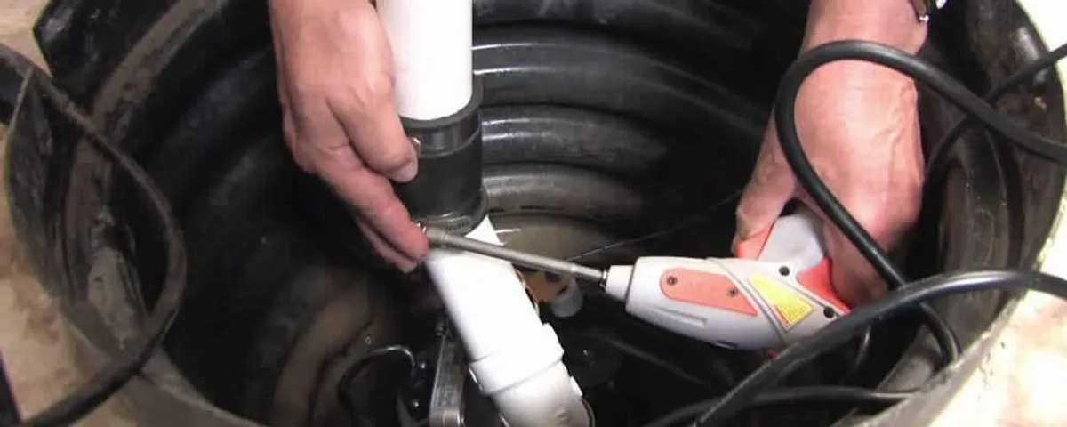 Sump pump installation technician connecting PVC discharge piping in Royal Oak, MI